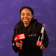 a woman holding a bottle of champagne and a moneygun