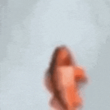 a blurry picture of a woman standing in front of a white background .