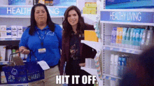 two women are standing next to each other in a store and one of them is holding a shopping basket .