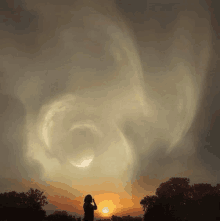 a person taking a picture of a sunset with a swirl of clouds in the sky