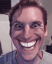 a close up of a man making a funny face with a big smile .