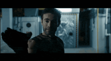 a man with a beard is standing in a dark room looking at the camera