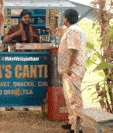 a man is standing in front of a sign that says ' 's canti ' on it