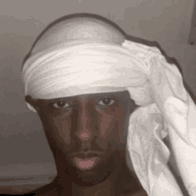 a man with a bandage on his head and a white towel around his neck