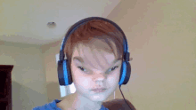 a young boy wearing headphones is making a face