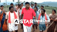 a man in a red shirt stands in front of a group of people with the words star tamil chat on the bottom