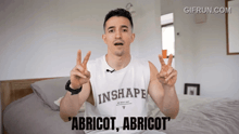 a man wearing a white tank top that says " inshape " on it