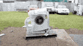 a whirlpool washing machine sits on a wooden pallet outside