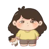 a girl in a yellow shirt is holding a doll