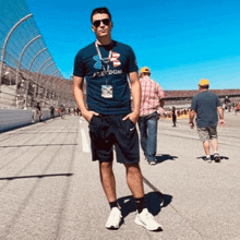 a man is standing on a race track wearing a blue shirt that says freedom .