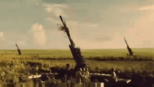 a group of soldiers are standing in a field with a cannon .