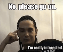 a man with dreadlocks has his finger on his forehead and says no please go on i 'm really interested