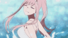 a girl with pink hair is standing in the water with her eyes closed .