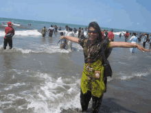 a woman in a green dress is standing in the ocean