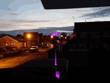 a purple light is lit up in the middle of a residential street