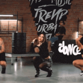 a woman is squatting in front of a sign that says ' trep urban '