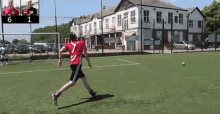 a man in a red shirt is kicking a soccer ball on a field with a scoreboard in the background that says 6 1