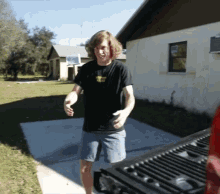 a man wearing a black shirt that says ' i love you ' on it is standing in front of a house