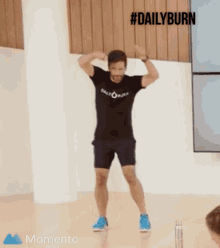 a man in a daily burn t-shirt is jumping in the air