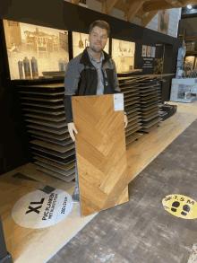 a man holding a piece of wood in front of a sign that says xl pvc platen