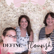 three women standing in front of a wall of flowers with the words define and flourish written on the bottom