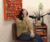 a woman sits in front of a microphone in front of a bookshelf with a book titled life is just on it