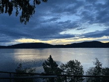 a large body of water with mountains in the background at sunset