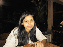 a woman sitting at a table with a fork and knife in her hand