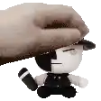 a hand is putting a hat on a stuffed animal with a knife .