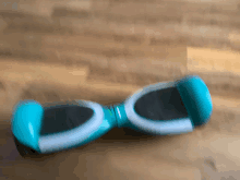 a blurred image of a blue hoverboard on a wooden floor