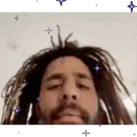 a close up of a man 's face with dreadlocks and a beard