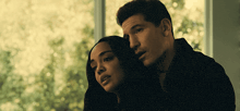 a man and a woman looking out a window