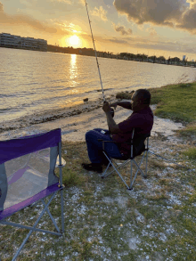 a man sits in a folding chair holding a fishing rod