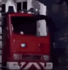 a red toy fire truck is parked in front of a building in the dark .