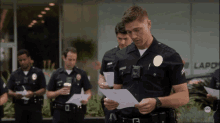 a group of police officers are standing in front of a building that says lapo