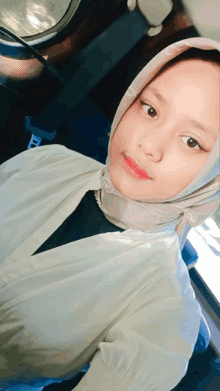 a young girl wearing a hijab and a white shirt