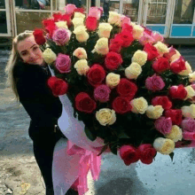 a woman is holding a large bouquet of flowers .