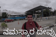 a man with a backpack is standing in front of a building in a parking lot in a foreign language