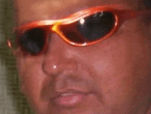 a close up of a man wearing sunglasses and making a face .