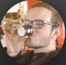 a man wearing glasses is drinking from a cup that says coca cola on it