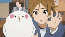 a boy with brown hair is holding a white chicken