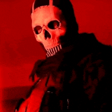 a person wearing a skull mask is holding a microphone in a dark room .