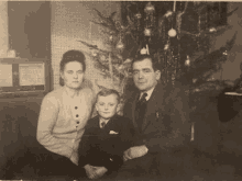 a family sitting in front of a christmas tree