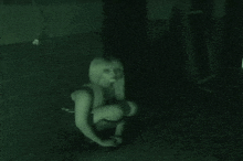 a woman is squatting on the floor in a dark room