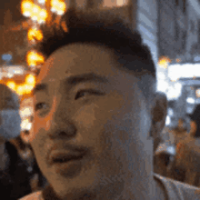 a close up of a man 's face in front of a crowd of people .