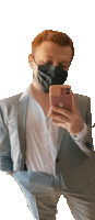 a man wearing a mask takes a selfie with his iphone