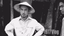 a black and white photo of a man wearing a conical hat and the year 1977 vlog