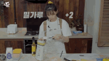 a woman in an apron is preparing food in a kitchen with a box of flour on the counter .