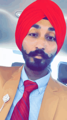 a man with a beard wearing a red turban and a red tie