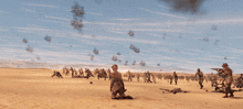 a group of soldiers are kneeling down in the desert